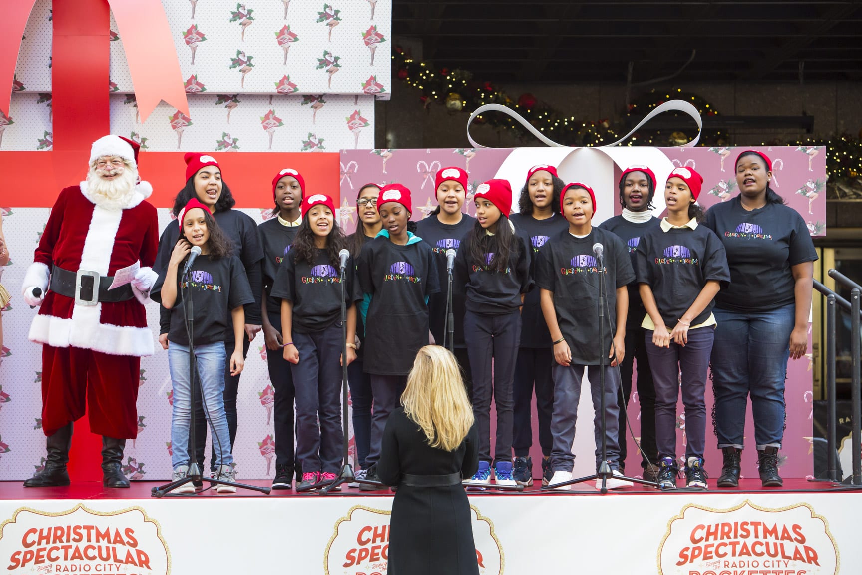 November 16, 2016: The Radio City Rockettes and Santa are joined by girls from the Garden of Dreams Foundation to sing on a float outside of Radio City Music Hall in New York City.